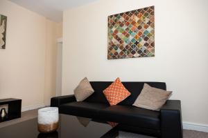 a living room with a black couch and a painting at South Shields Central in South Shields