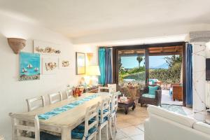 jadalnia ze stołem i krzesłami oraz salon w obiekcie Casa Gaia al mare w mieście Olbia