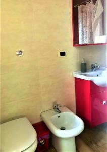 uma casa de banho com um WC branco e um lavatório. em Guest House Loriano em Marcianise