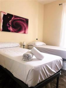 duas camas num quarto com um quadro na parede em Guest House Loriano em Marcianise