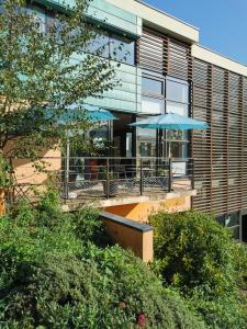 a building with a patio with a blue umbrella at Auberge de Jeunesse HI Rouen in Rouen