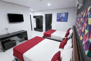 Habitación de hotel con 2 camas y TV en Hotel Dwana en Mazatlán