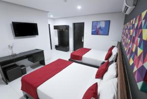 a hotel room with two beds and a tv at Hotel Dwana in Mazatlán