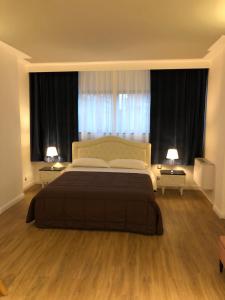 a bedroom with a large bed and two windows at A&F Apartment Padova Piazza Garibaldi in Padova