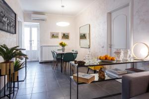 un soggiorno con tavolo e una sala da pranzo di Suite La Pergola - Centro Storico a Catania