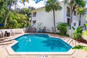 a swimming pool in front of a house with palm trees at Boca Grande Hotel in Boca Grande
