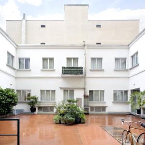 een wit gebouw met planten op de binnenplaats bij UP to home - Città Studi in Milaan