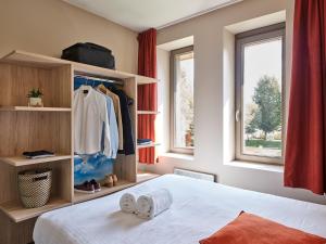 a bedroom with a bed and a window at Holiday Suites Westende in Westende