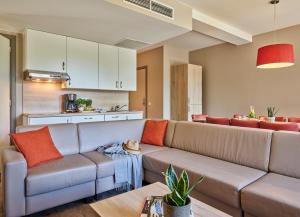 a living room with a couch and a kitchen at Holiday Suites Westende - Middelkerke in Middelkerke