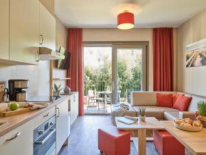 una cucina e un soggiorno con divano e tavolo di Holiday Suites Westende a Middelkerke