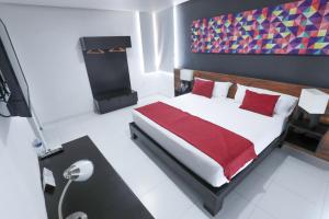 1 dormitorio con 1 cama grande con almohadas rojas en Hotel Dwana en Mazatlán