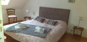 ein Schlafzimmer mit einem Bett mit zwei Handtüchern darauf in der Unterkunft Le Cocon Breton in Trébeurden
