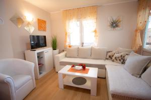 a living room with a white couch and a table at Apartman Sanja Divčibare in Divčibare