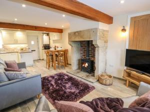 a living room with a couch and a fireplace at Mirk Cottage in Hebden Bridge