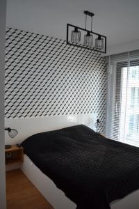 a bedroom with a black and white patterned wall at Apartamenty DK9 Promenada Gwiazd 14 in Międzyzdroje