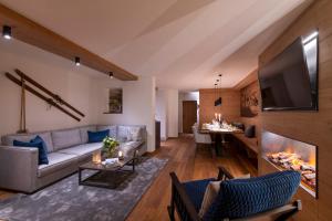 a living room with a couch and a tv at Brunnenhof Luxury Apartments in Lech am Arlberg