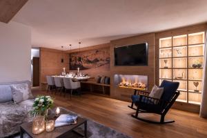 un soggiorno con camino e una sala da pranzo di Brunnenhof Luxury Apartments a Lech am Arlberg
