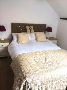 una camera da letto con un grande letto con due comodini di 1 The Mews Cottages a Ledbury