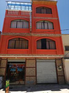 a red brick building with two garage doors at Hostal Olas Del Titicaca in Copacabana