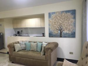 a living room with a couch and a tree on the wall at Mideya Gardens in Nairobi