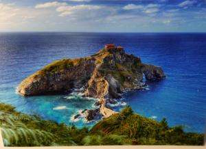 a small island in the ocean with a house on it at Lamerie in Bermeo