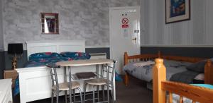 a bedroom with a bed and a table and chairs at Bannockburn Inn in Helmsdale