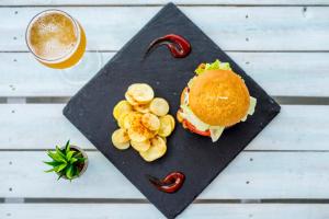 a black plate with a sandwich and chips and a drink at Camelina Suites in San Antonio Bay
