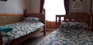 a bedroom with a twin bed and a bedspread on a bed at Bannockburn Inn in Helmsdale