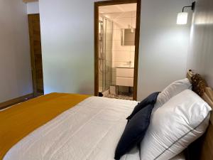 een slaapkamer met een groot bed en een badkamer bij Clos De La Charnaille in Cousance