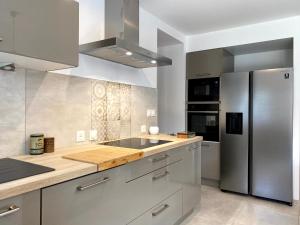 a kitchen with a stainless steel refrigerator and cabinets at Clos De La Charnaille in Cousance