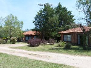 une maison avec un chemin de terre devant elle dans l'établissement Yerba Buena casas de campo - Arroyo de los Patos, à Nono