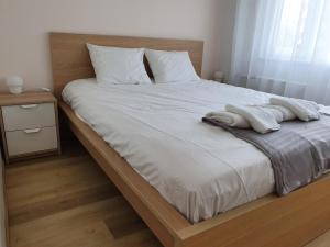 een bed met witte lakens en 2 handdoeken erop bij Over The River Apartment in Tartu