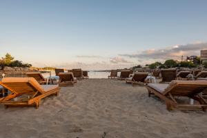 a group of chairs and tables on a beach at Camelina Suites in San Antonio Bay