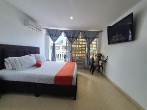1 dormitorio con 1 cama y TV de pantalla plana en Hotel Royal Plaza, en Villavicencio