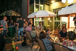 un groupe de personnes assises sur une terrasse avec des chaises dans l'établissement Br Hostel, à Belo Horizonte