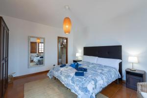 a bedroom with a bed with a blue comforter at The Yellow House - Solarium - Climatized Pool in Gáldar +43 photos