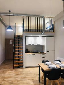 a kitchen and dining room with a table and a loft at Property Apart - Soft Lofty Legnicka Centrum in Wrocław