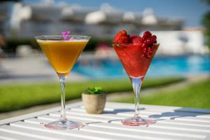 two cocktails sitting on top of a table with strawberries at Camelina Suites in San Antonio Bay