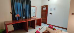 Equator Holiday Inn في Fuvahmulah: غرفة معيشة مع مكتب ومرآة