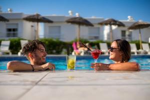 a man and woman sitting in a pool with drinks at Camelina Suites in San Antonio Bay