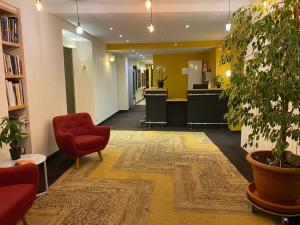 a lobby with a red chair and a waiting room at Le Miredames Hôtel-Bar in Castres