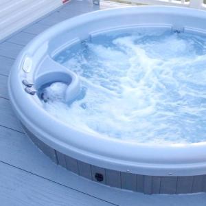a jacuzzi tub filled with blue water at Celebration Tattershall with Private Hot Tub in Tattershall
