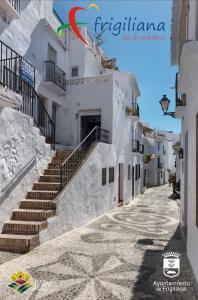 una calle en una ciudad con edificios blancos y escaleras en Casa David, en Frigiliana