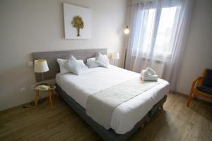 Un dormitorio con una gran cama blanca y una ventana en Hôtel Pyrène, en Foix
