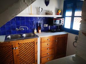 cocina con fregadero y azulejos azules en la pared en Casa David, en Frigiliana