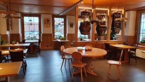 维尔德斯韦尔Gasthof Hirschen in Wilderswil的餐厅设有木桌、椅子和窗户。