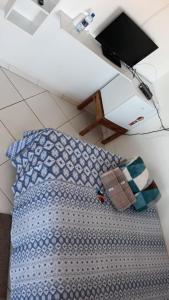 Schlafzimmer mit einem Bett mit einem Kissen und einem TV in der Unterkunft Quarto Suíte Itapoá - SC in Itapoa