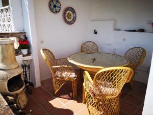 comedor con mesa y sillas de mimbre en Casa David, en Frigiliana
