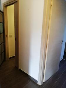 Zimmer mit einer weißen Wand und einer Tür in der Unterkunft lo zahir in Marina di Ragusa