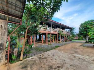 a building with trees in front of it at Maan Mork Khao Kho in Khao Kho